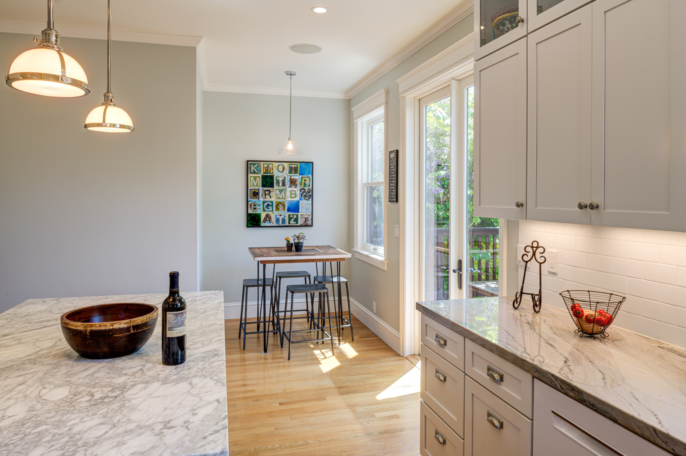 Updated kitchen layout with functional marble countertops, ample natural light, and expanded space in Alameda Addition renovation.