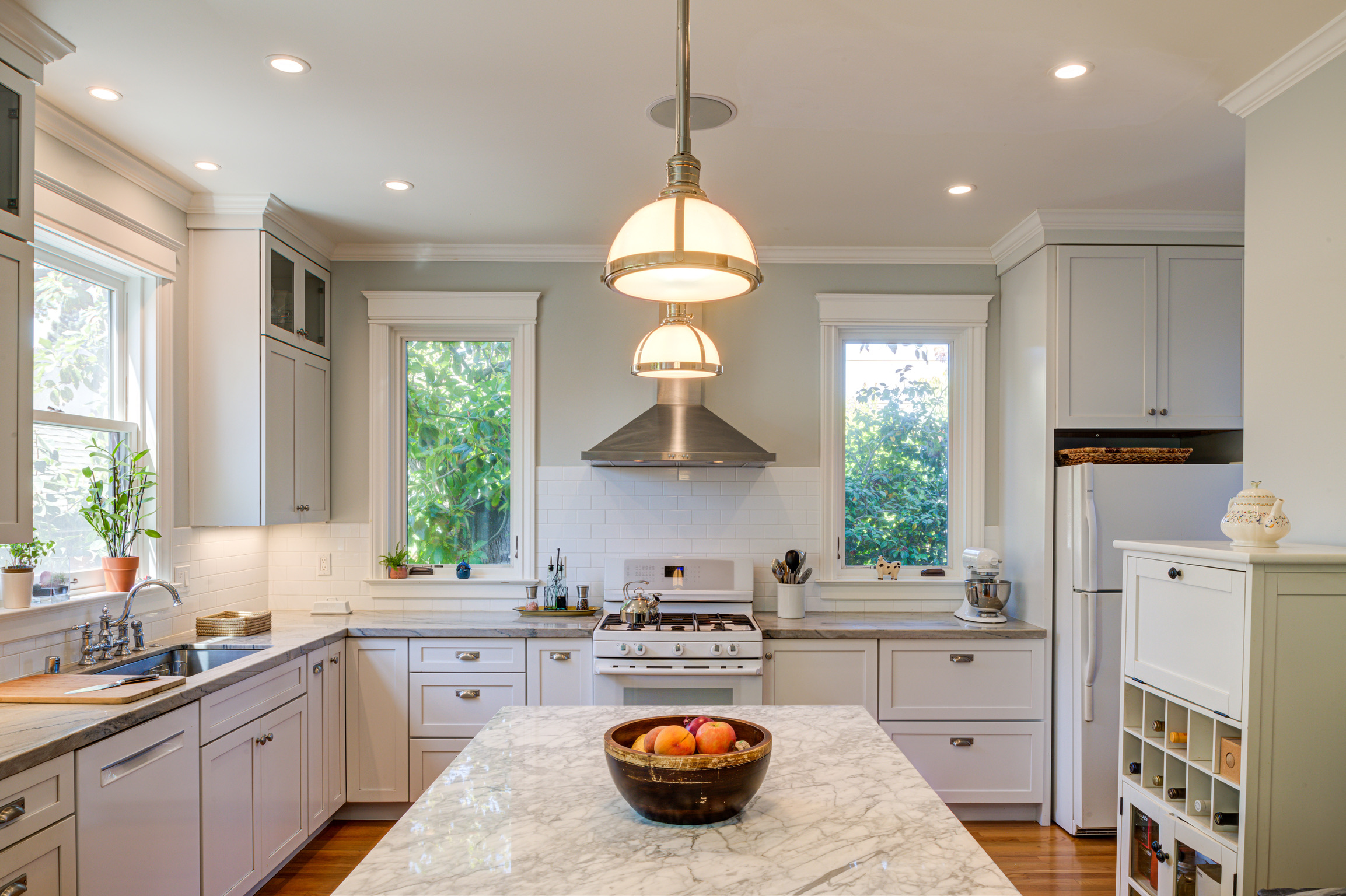 Kitchen features updated cabinetry, large island, modern appliances, and ample windows providing abundant natural light.