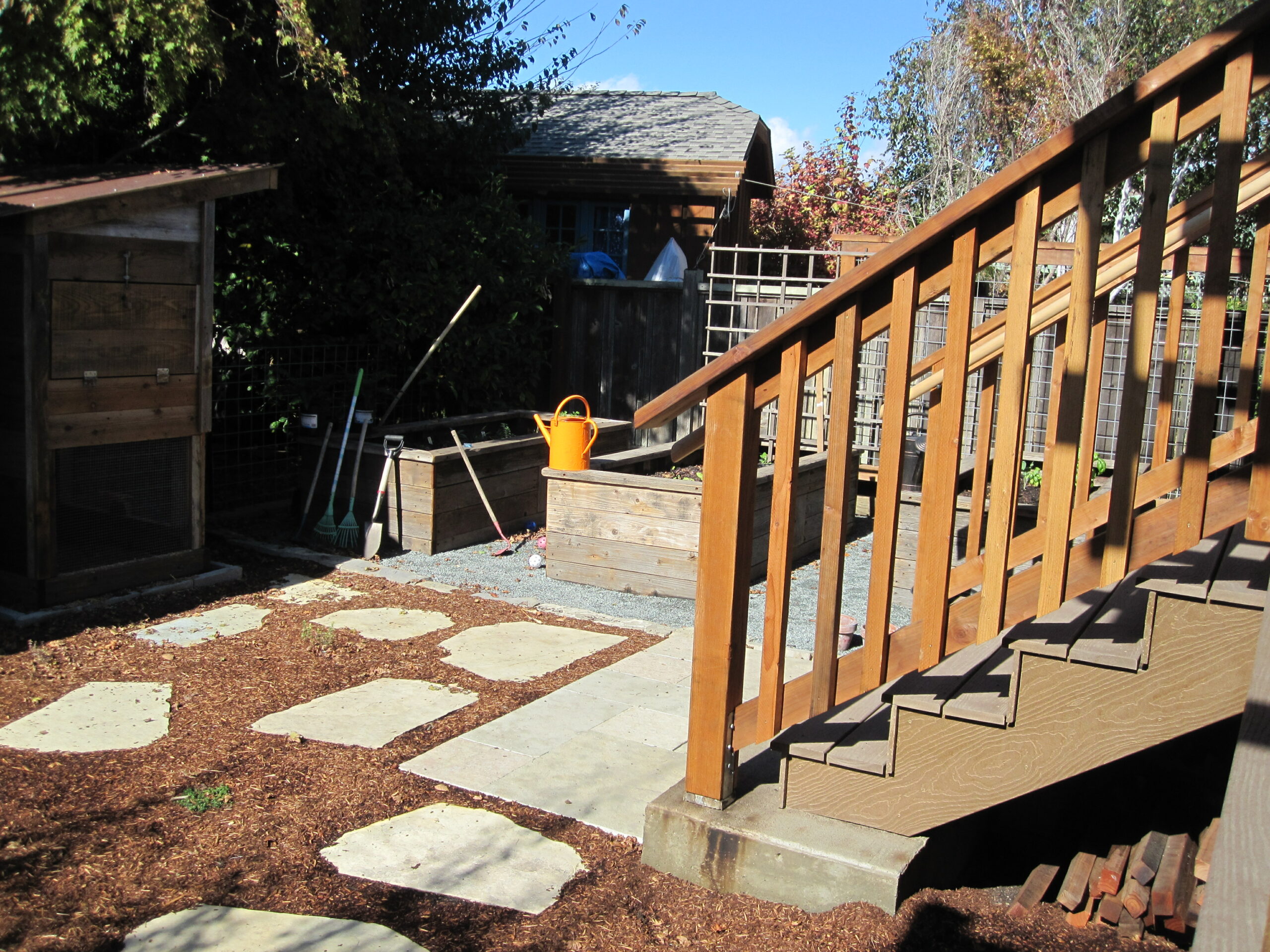 Backyard with functional raised beds, durable shed, sturdy stairs, mulched walkway, and practical garden tool storage potential.