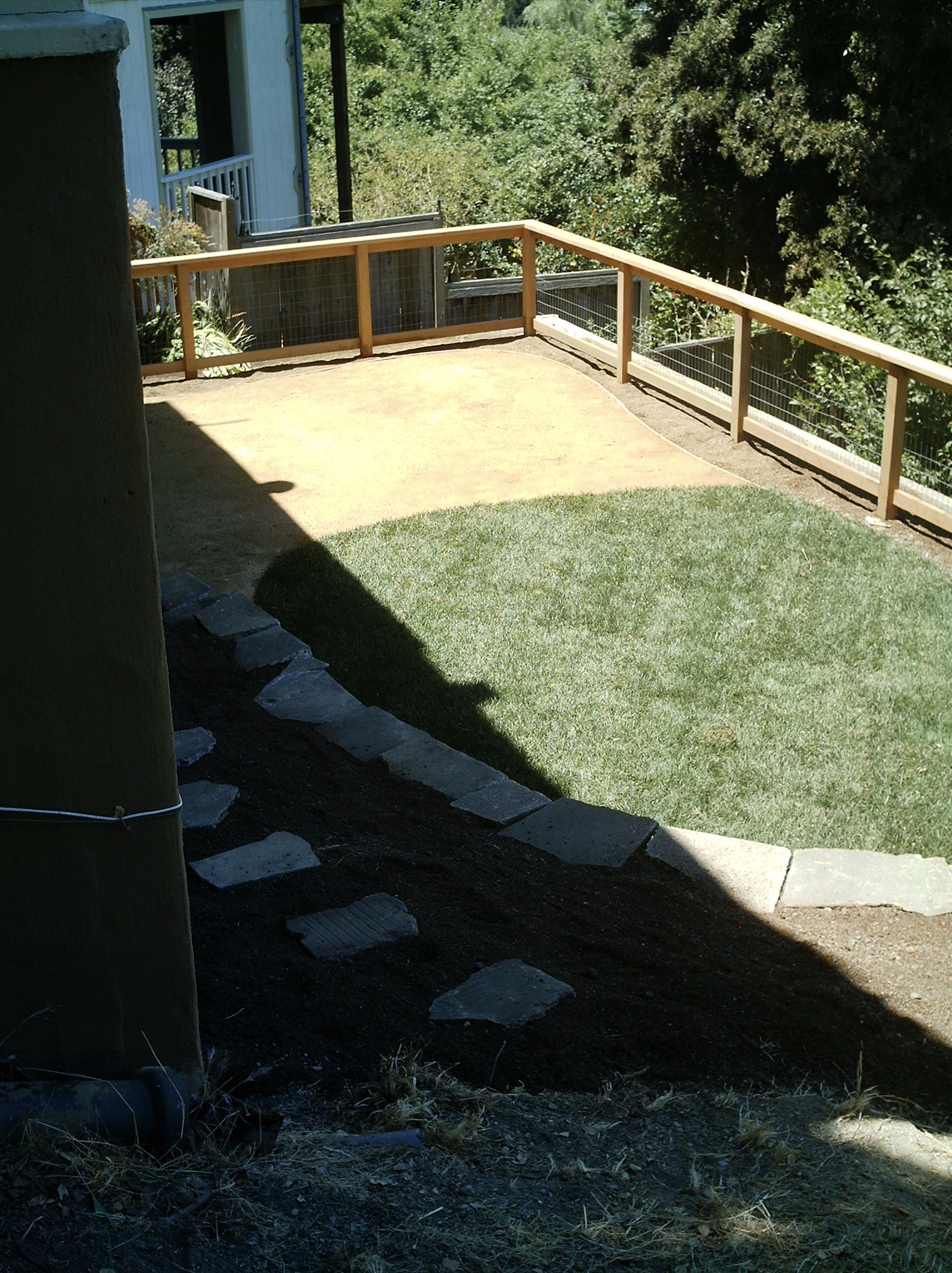 Crocker Highlands backyard with grass and dirt areas, established trees, wood fencing, and stone steps offering redevelopment potential.