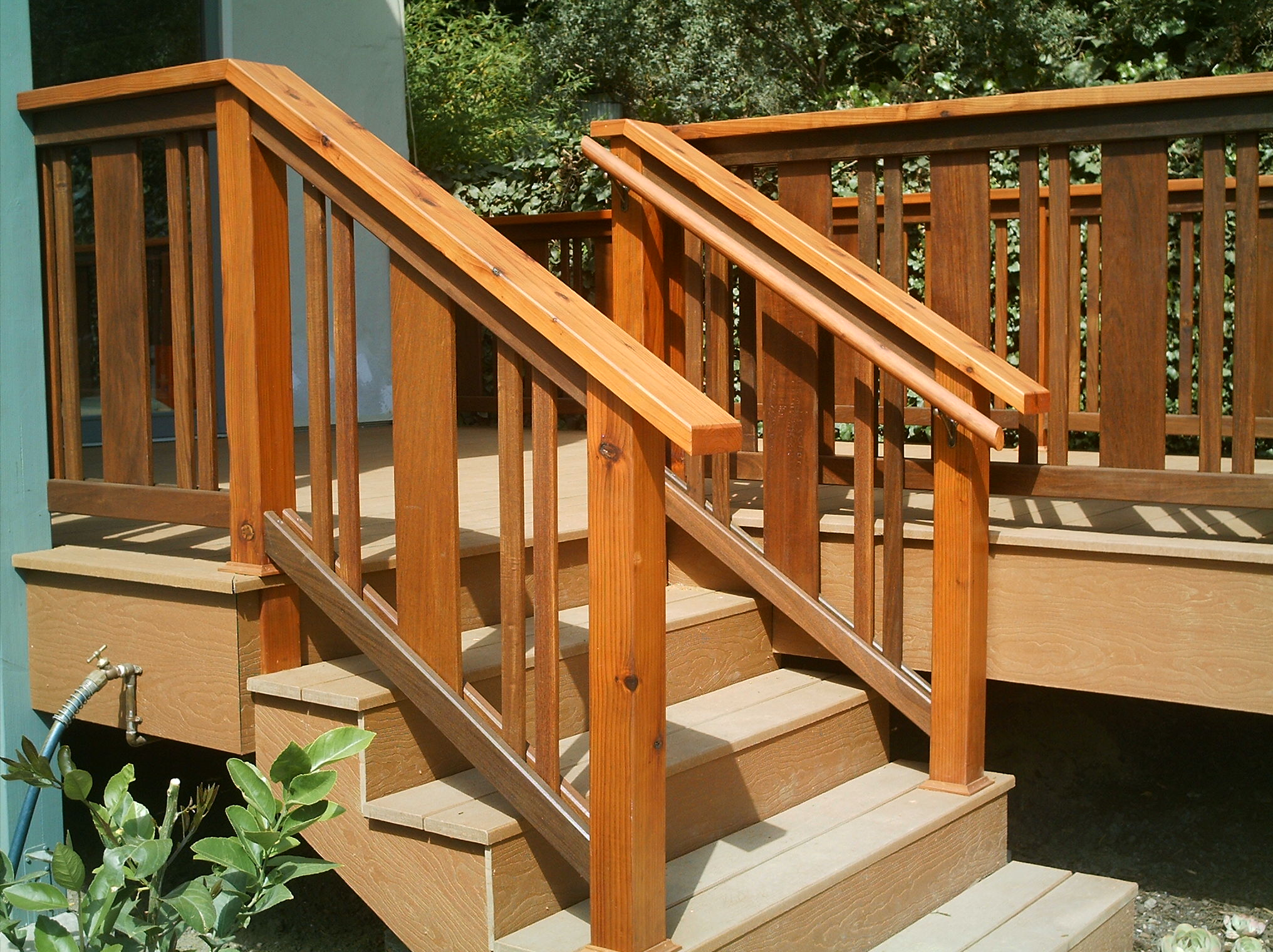 Sturdy wooden stairs with railings and vertical balusters provide safe access to a deck, demonstrating sound structural design.