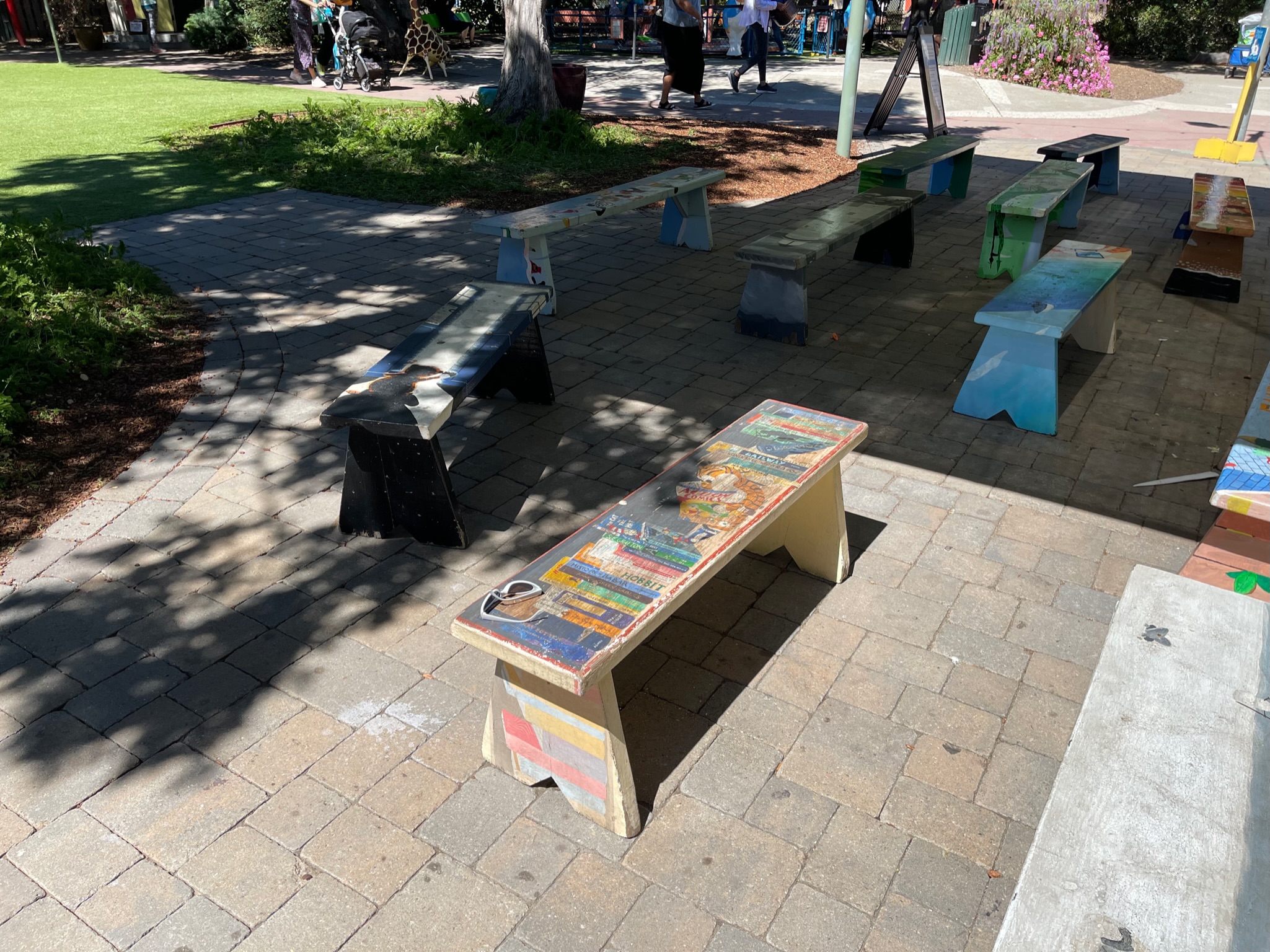 A paved area in an outdoor park offers open space with sun exposure and established landscaping, suitable for redevelopment.