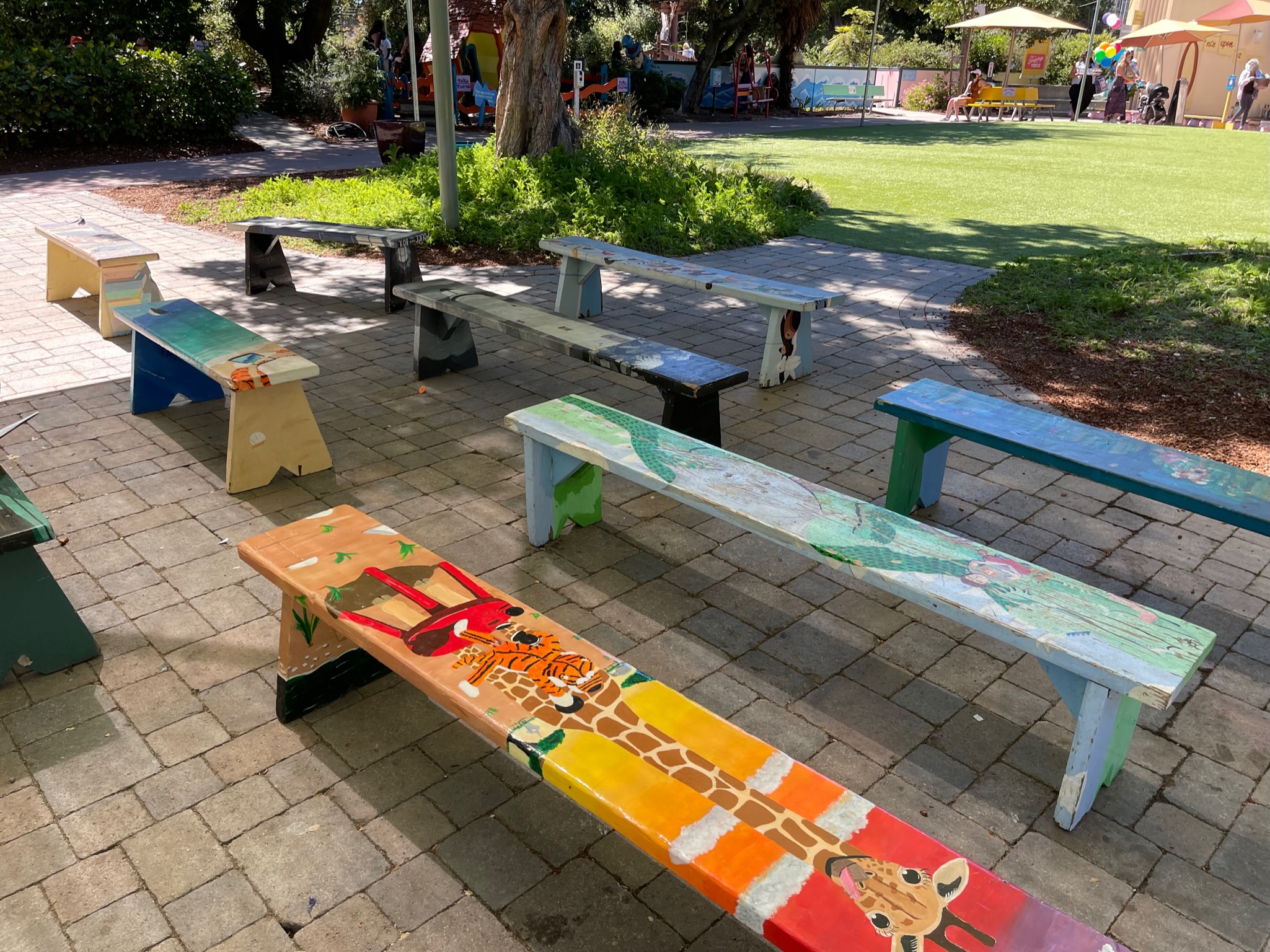 Paved outdoor area with open space and mature landscaping, offering potential for customized park or communal gathering redesign.