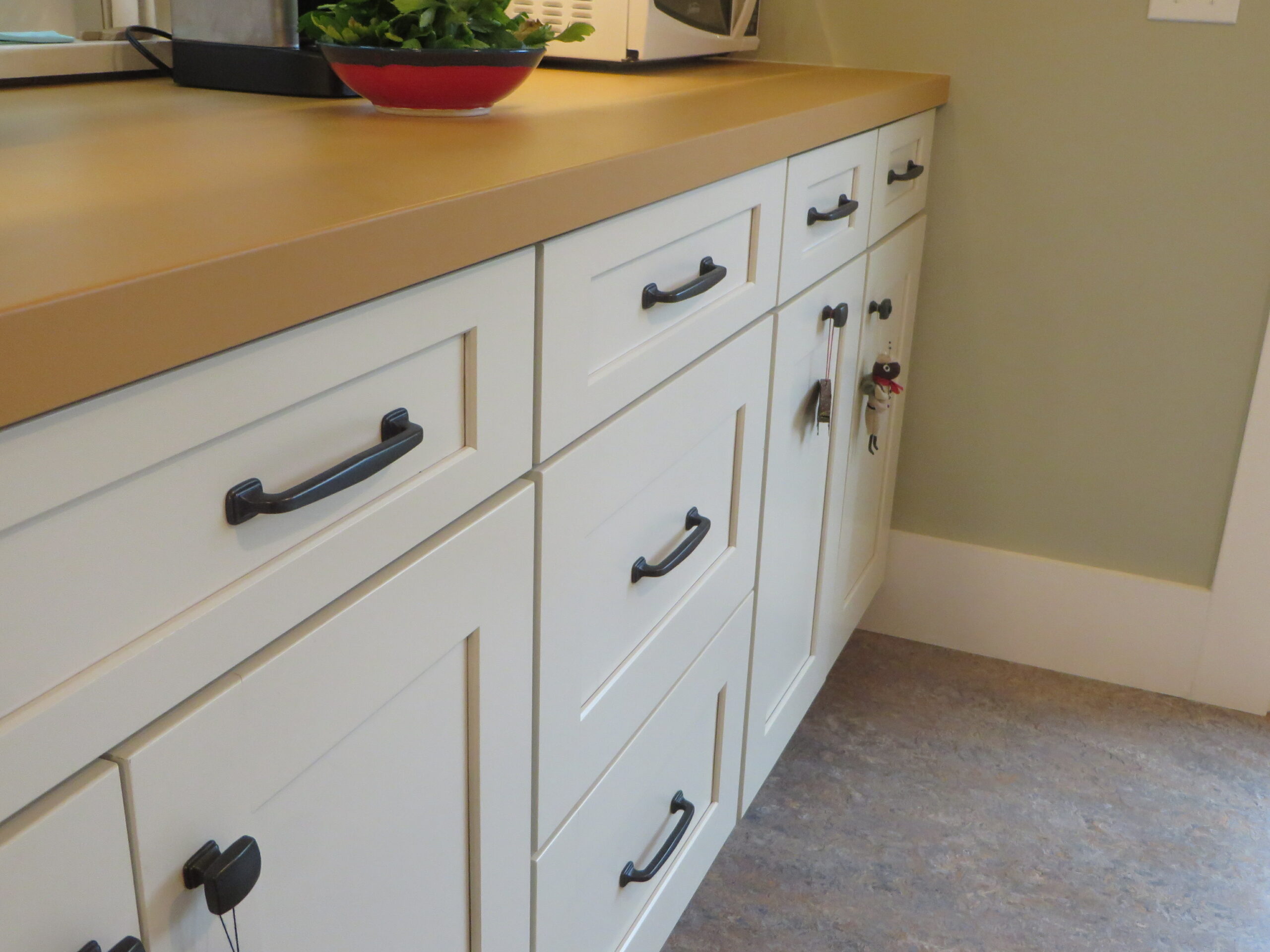Modern cabinets with updated hardware and durable countertops offer functional storage and work surfaces in a well-appointed kitchen.