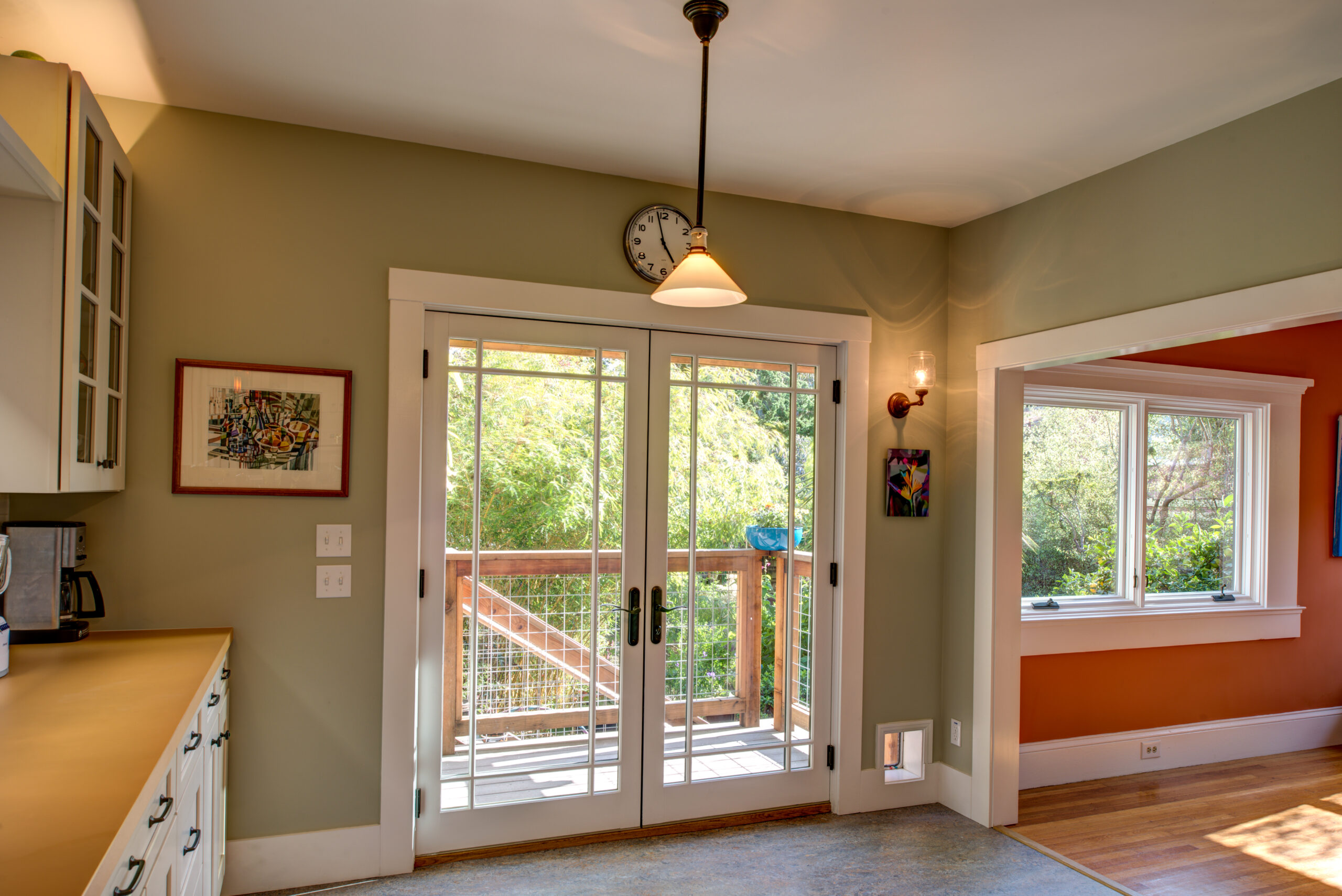 A North Oakland remodel with an open kitchen layout, glass doors maximizing light and access to a spacious outdoor deck area.