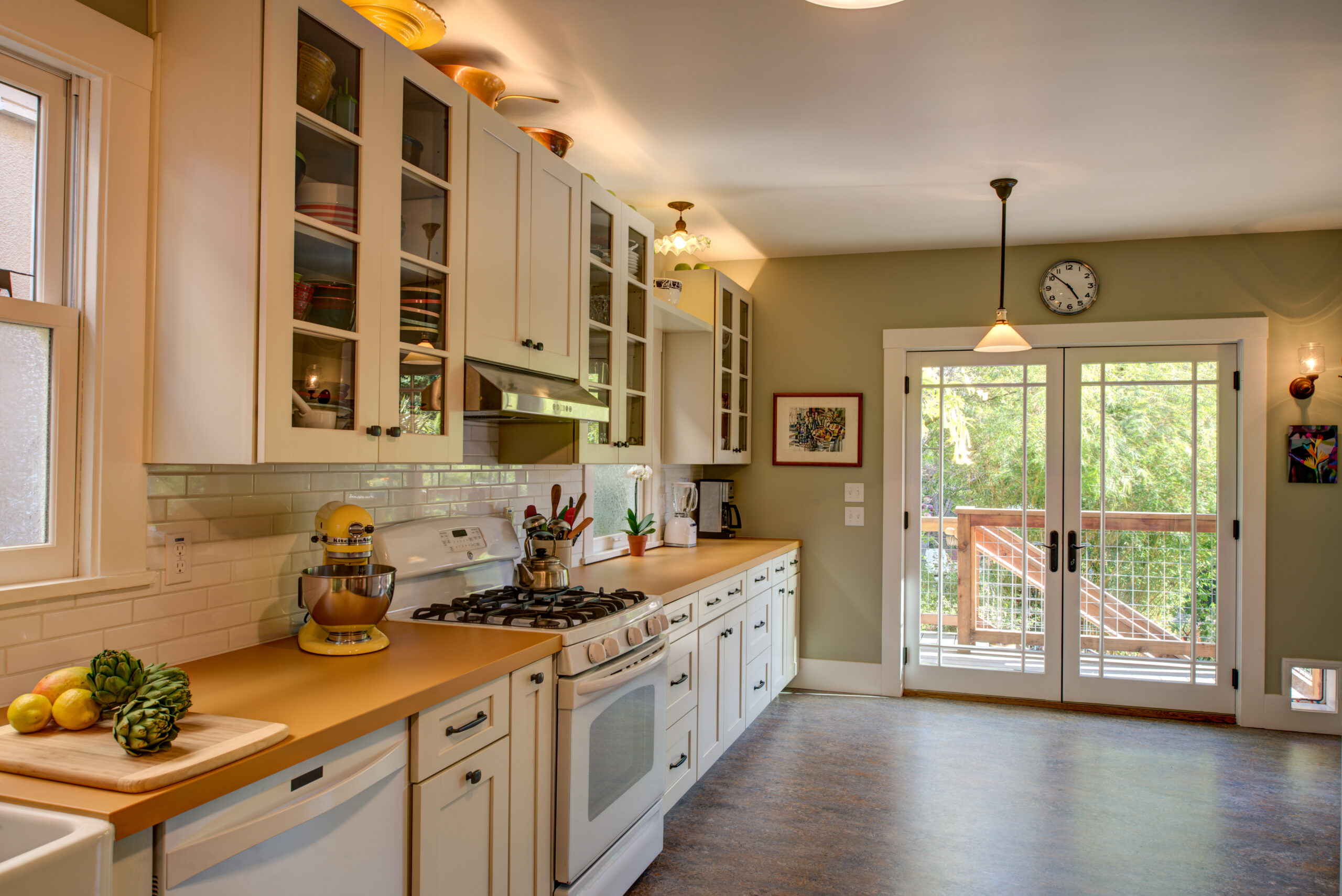 Renovated kitchen with open layout, efficient appliance setup, and glass doors offering access to outdoor living space.