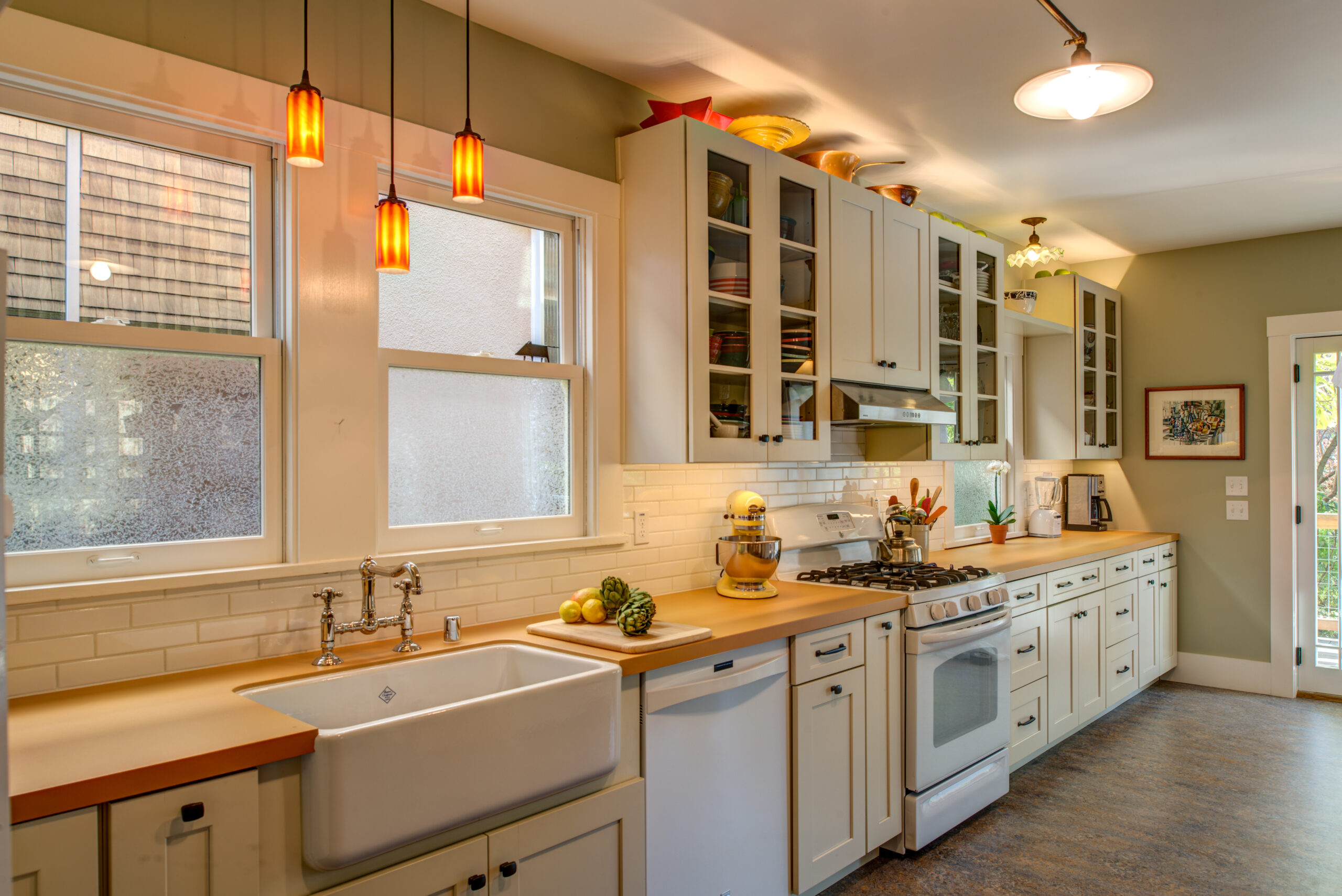 Updated North Oakland kitchen with new cabinetry, upgraded countertops, modern sink and stove, abundant natural light from two windows.