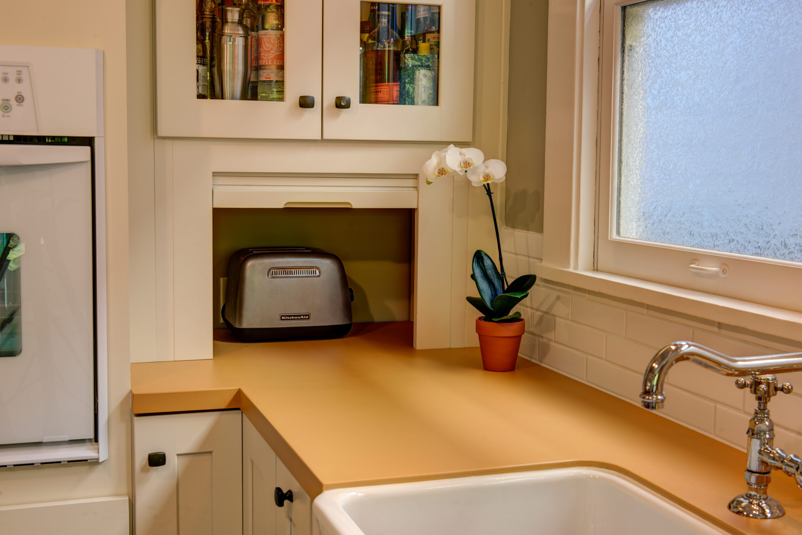 A remodeled North Oakland kitchen shows a functional countertop layout with built-in sink, ample natural light, and efficient storage.