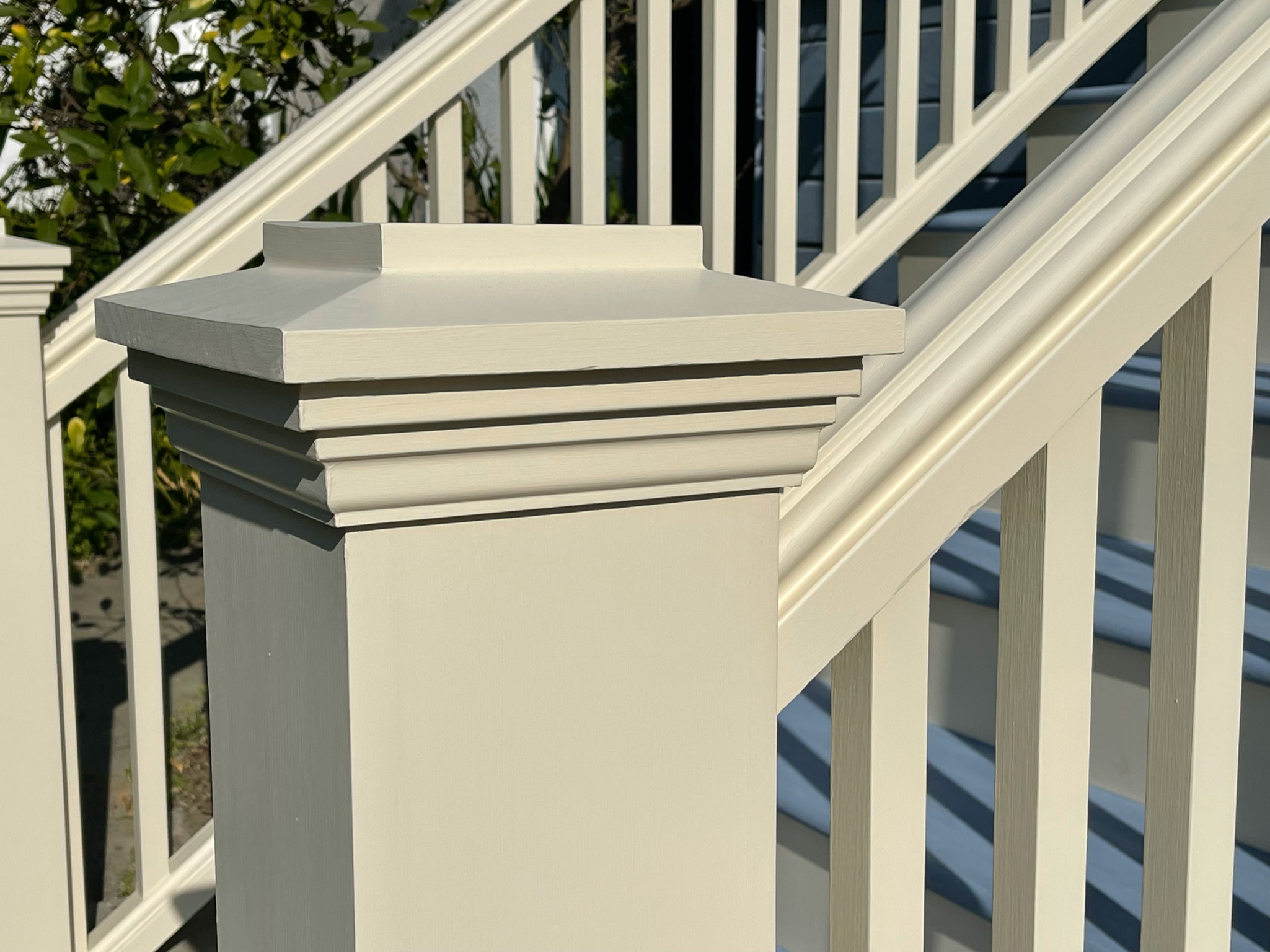 Close-up of a wooden stair railing and post with decorative trim, showing sturdy construction and craftsmanship suitable for renovation.