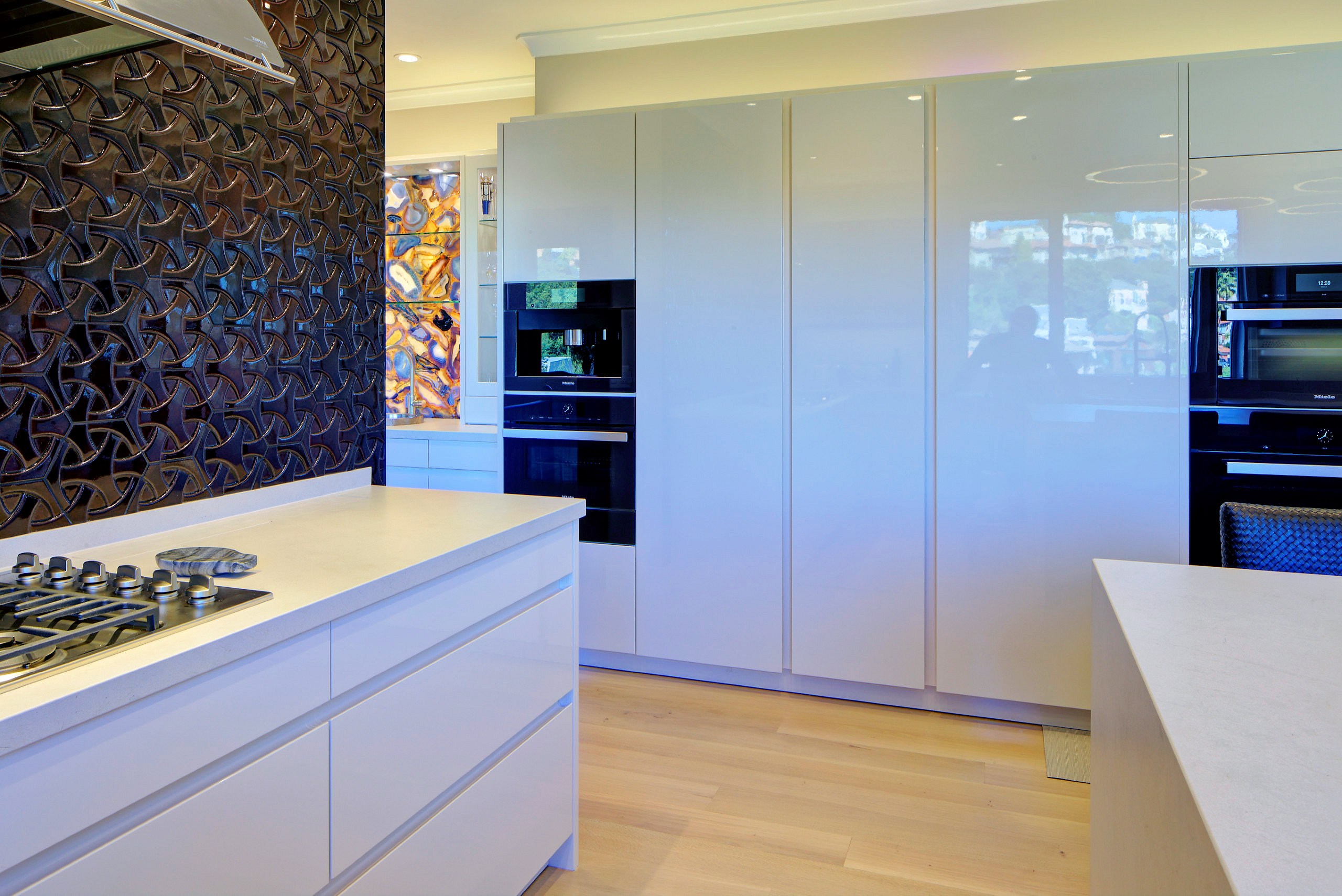 Spacious modern kitchen with built-in ovens, gas cooktop on island, open layout, quality cabinetry, and durable flooring.
