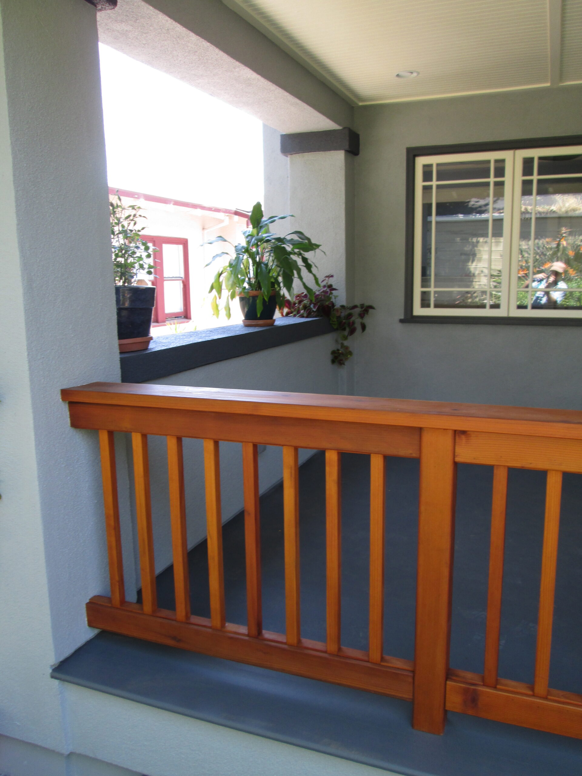 A porch structure in Oakland with sturdy railing, ample ledge space, window placement, and potential for outdoor kitchen upgrades.