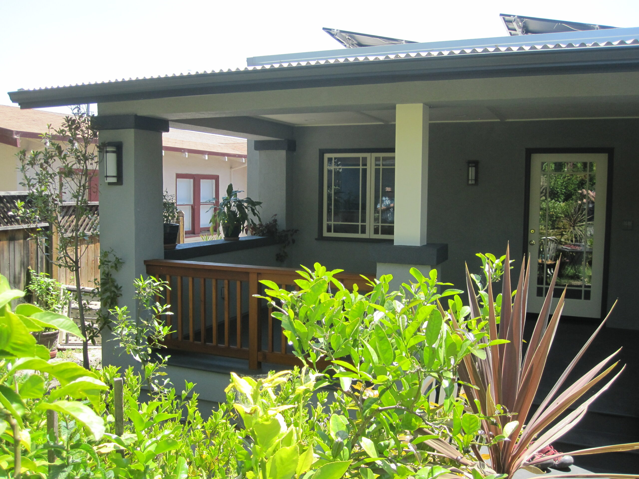 A modern Oakland house with a covered porch, durable wooden railing, large front yard potential, and spacious outdoor deck.