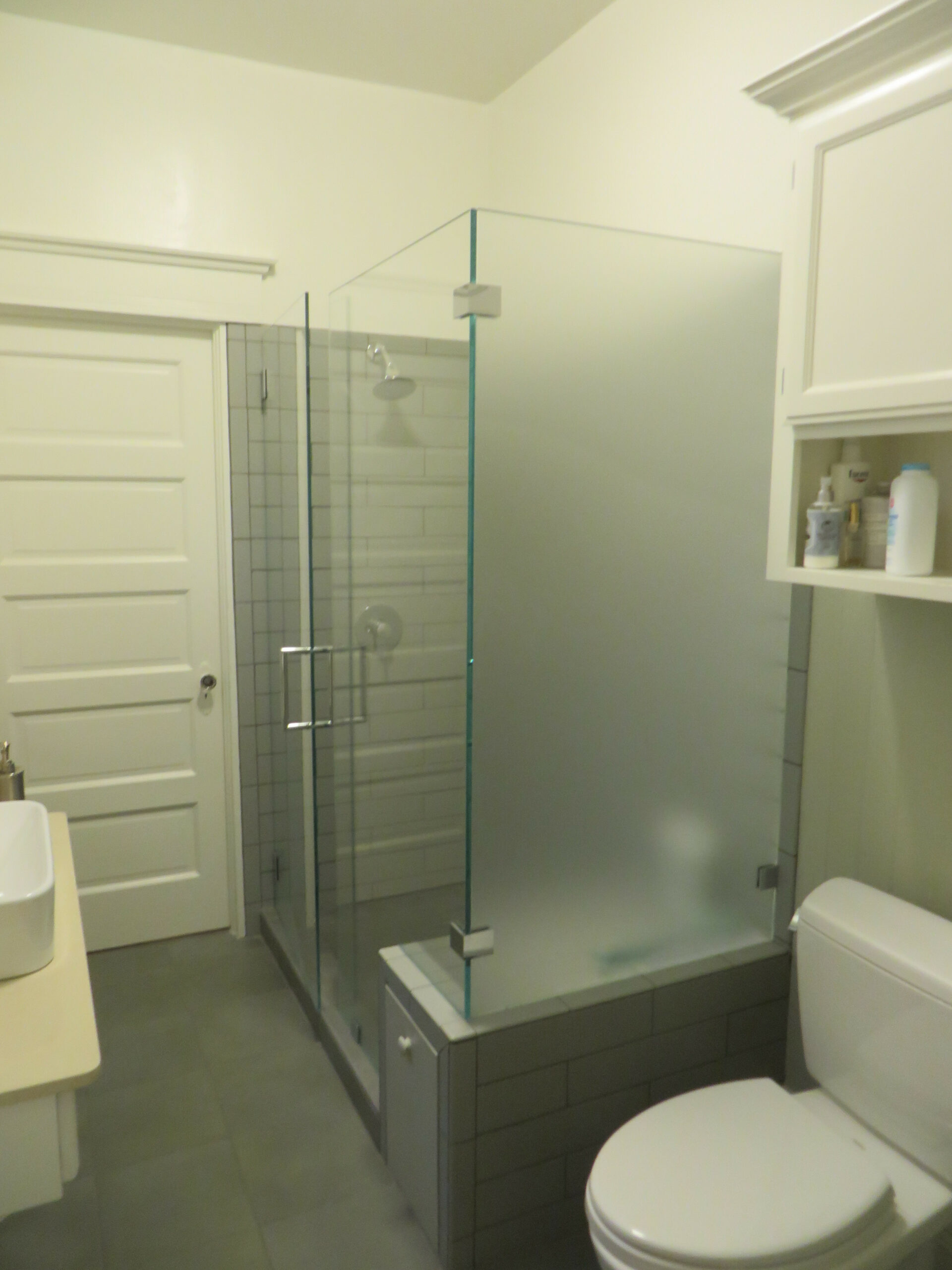 Modern Piedmont bathroom featuring a glass shower enclosure, built-in shelving, functional layout, and updated fixtures.