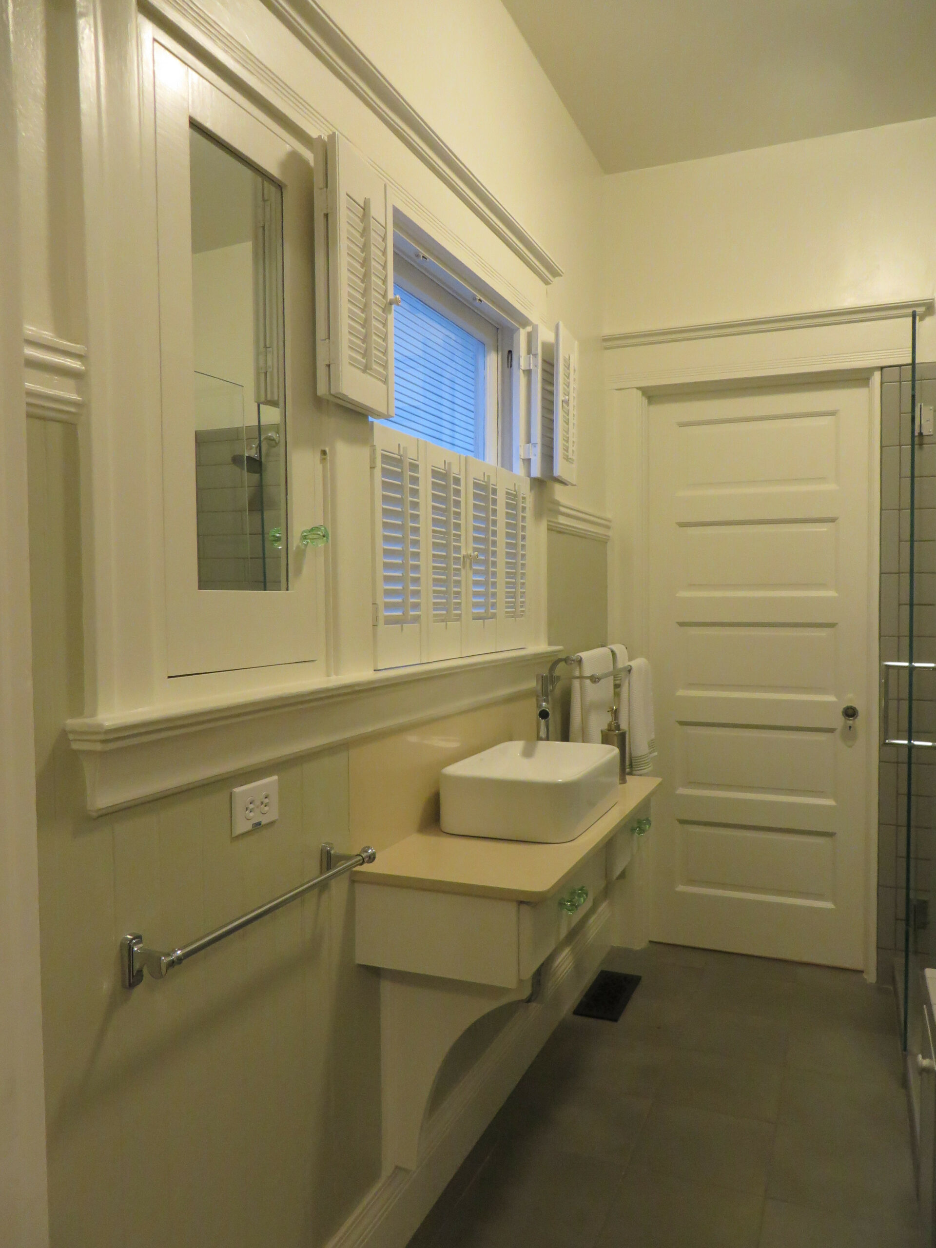 Piedmont Bathroom features upgrade potential with wall-mounted mirror cabinets, window shutters, and a glass shower enclosure.
