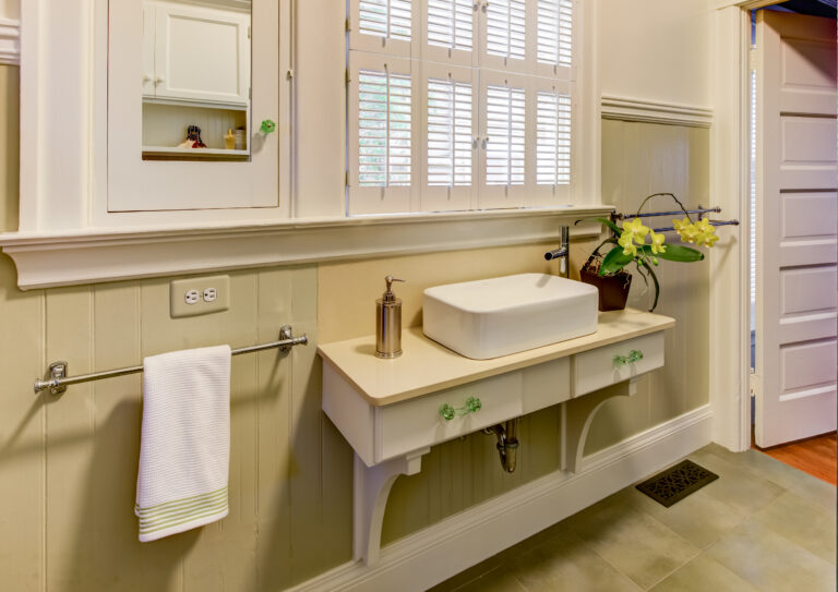 The renovated bathroom includes efficient fixtures: a rectangular sink, wall-mounted faucet, practical ventilation, and mirror.