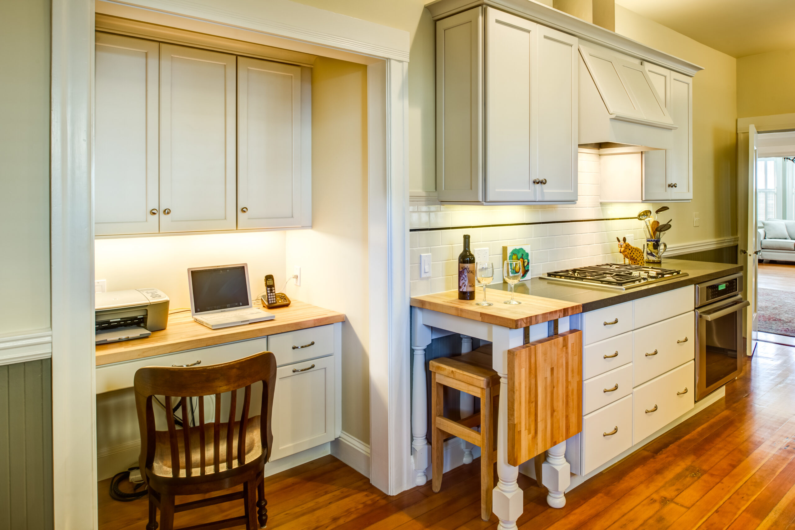 A Piedmont Remodel kitchen showcases functional cabinetry, a gas stove, integrated workspace, and durable hardwood flooring.