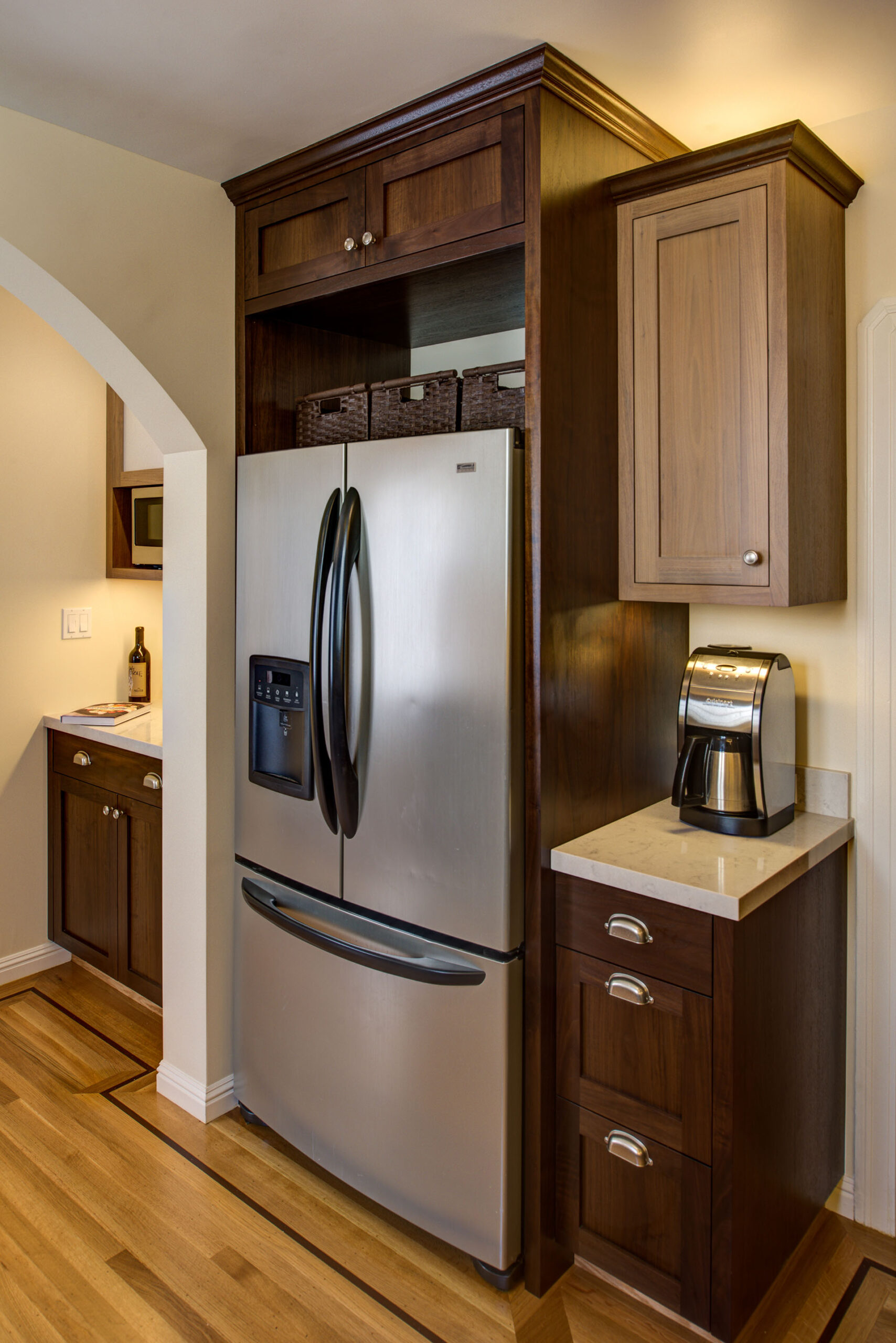 Built-in French door refrigerator maximizes kitchen layout efficiency, adjacent to a compact counter with integrated storage.