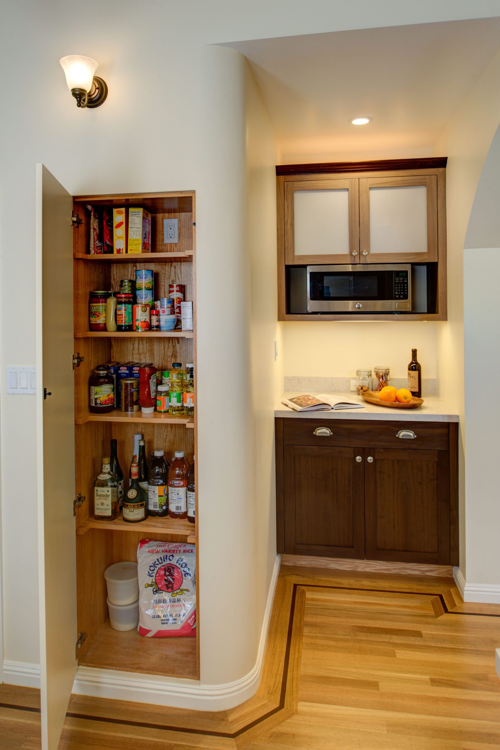 Compact pantry with efficient shelving is adjacent to a remodeled kitchenette featuring updated cabinets, appliances, and storage.