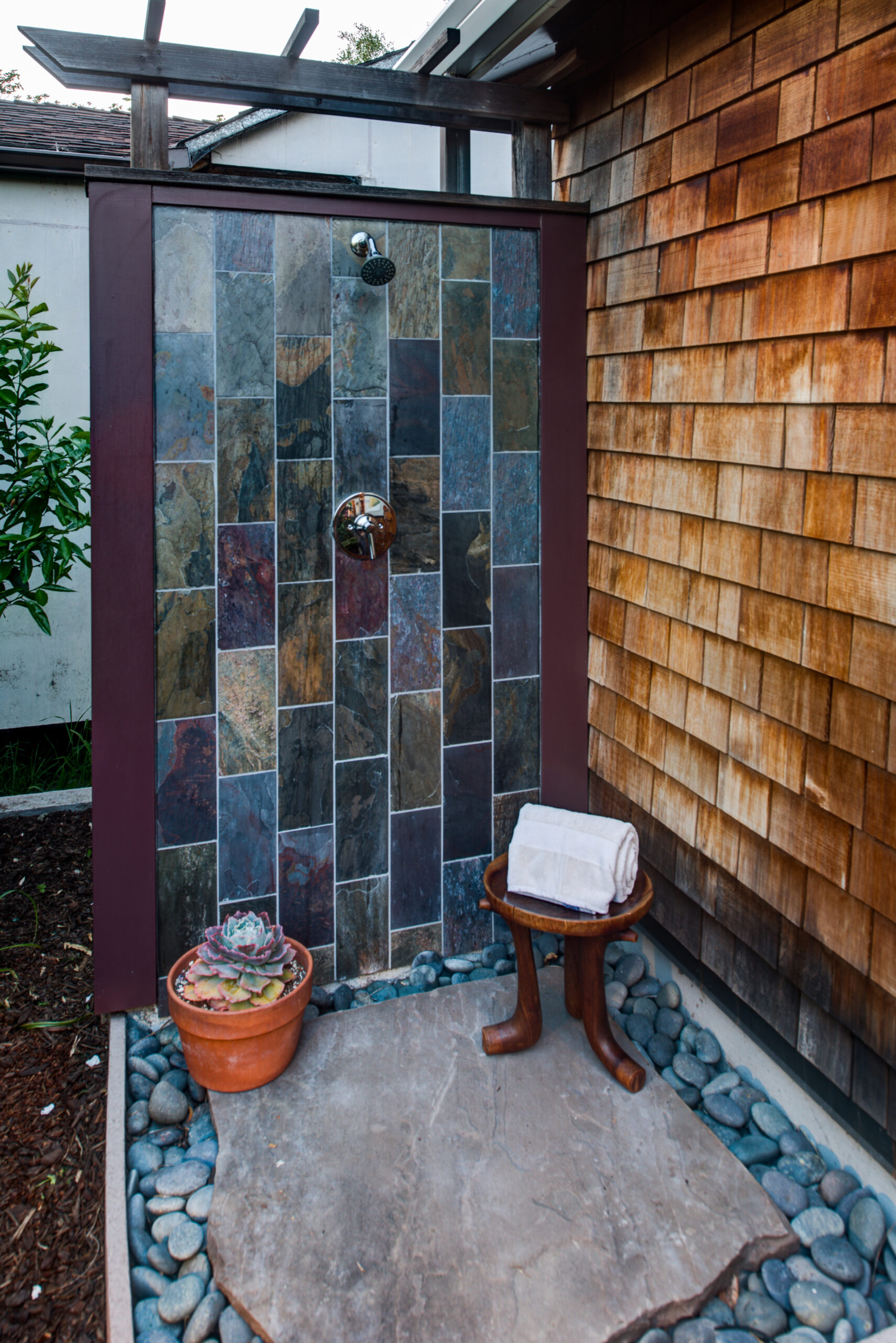 Backyard outdoor shower with durable slate tile walls, stone base, and efficient drainage—ideal for modern home upgrades.