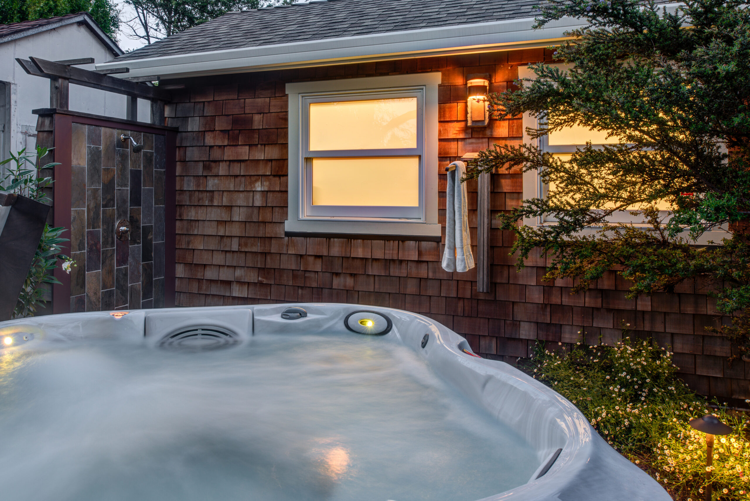 Backyard features a hot tub and outdoor shower, indicating upgraded plumbing and potential for desirable outdoor living amenities.