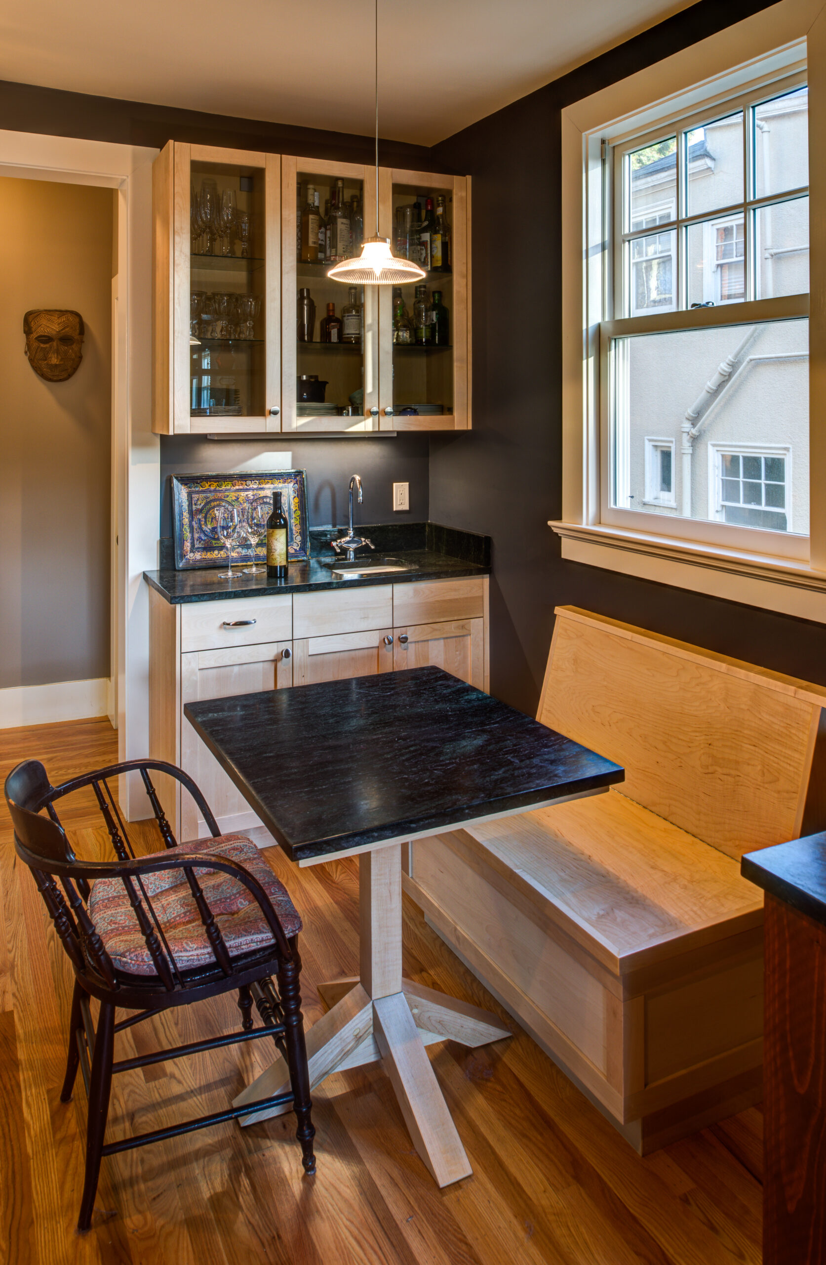 Compact dining nook from a Temescal Remodel with built-in storage solutions, efficient seating, and natural light via window.