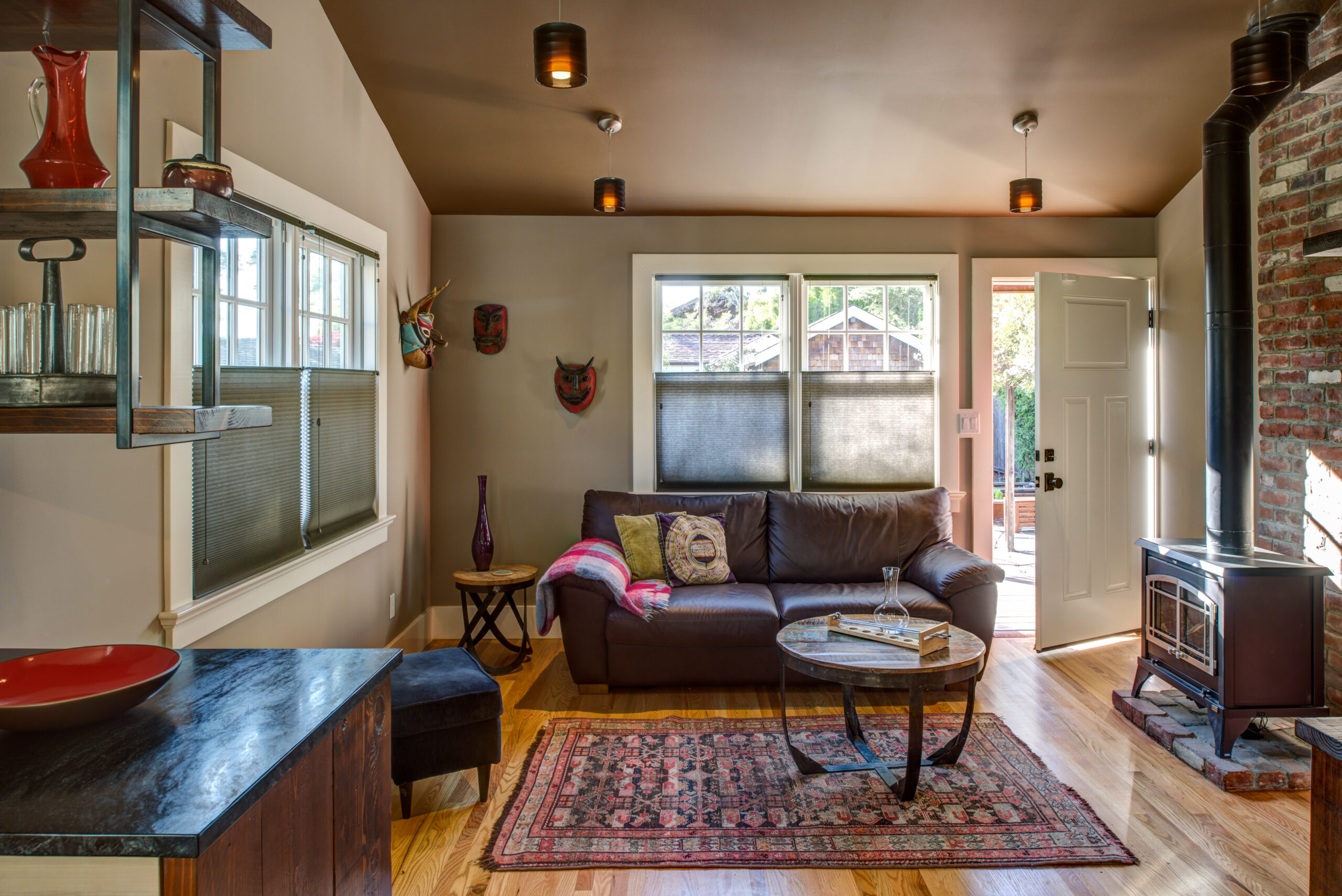 Living room in a recent Temescal remodel with open layout, wood stove, ample natural light, and seamless indoor-outdoor access.