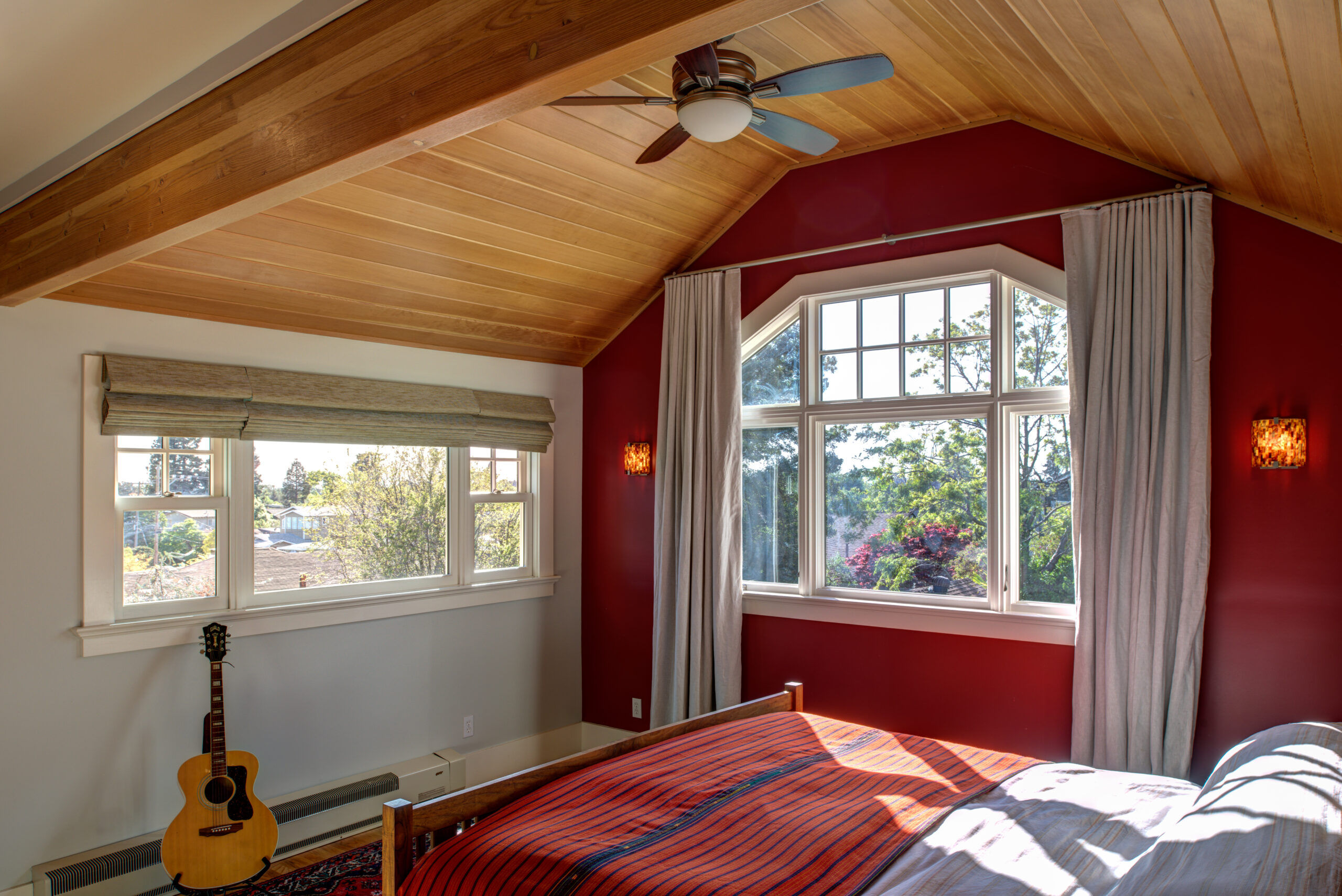 Bedroom in Temescal Remodel with updated wood ceiling, large windows for natural light, and efficient ceiling fan installation.