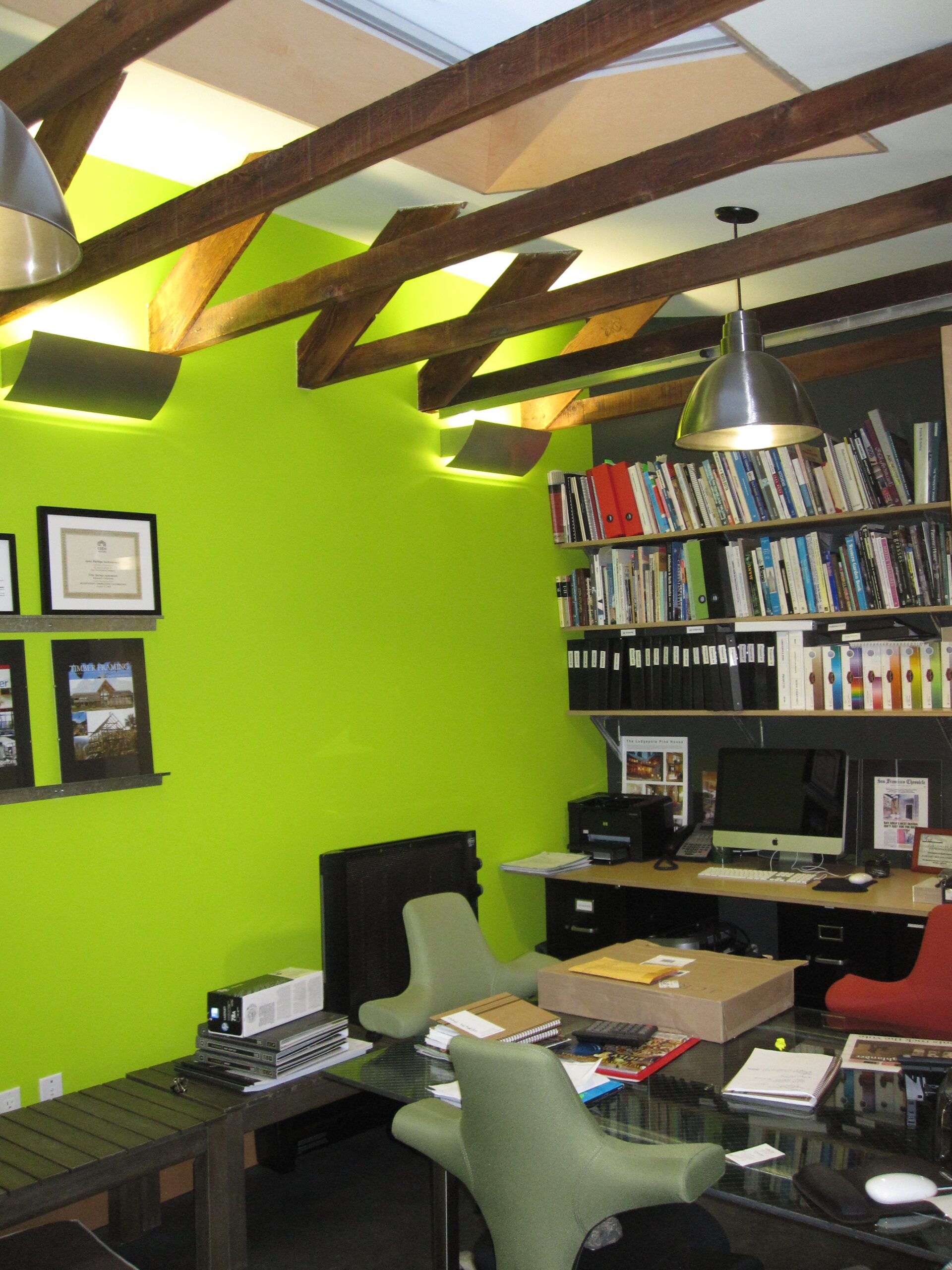 Modern West Berkeley office with exposed wood beams, open floor plan, built-in shelving, and ample natural light.