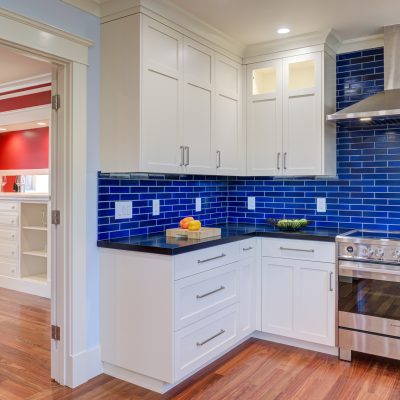 Oakland kitchen featuring updated cabinetry, quality tile backsplash, modern appliances, hardwood flooring, and open floor plan.
