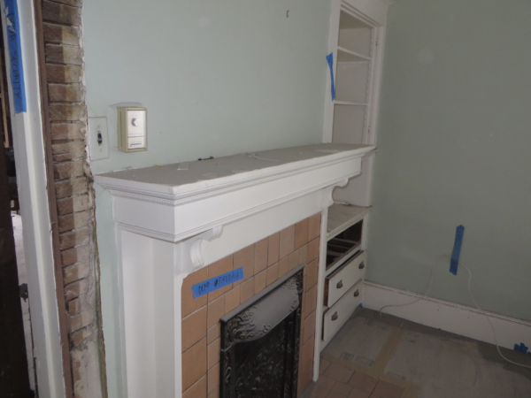 Fireplace mantel with tile surround, built-in shelving, and marked renovation zones indicating areas for structural updates.