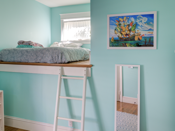 Room features maximized vertical space with a loft bed, efficient layout, and preserved architectural elements suited for redevelopment.